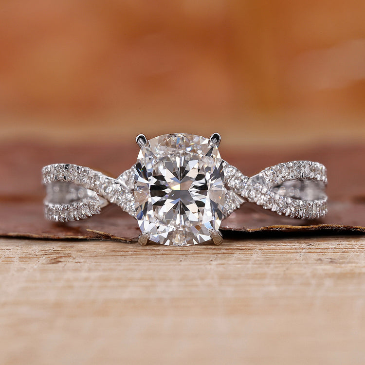 Elongated cushion cut diamond ring with a twisted pavé setting.
