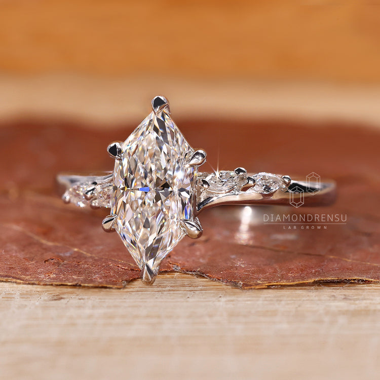 Buy engagement ring featuring marquise and round side stones.