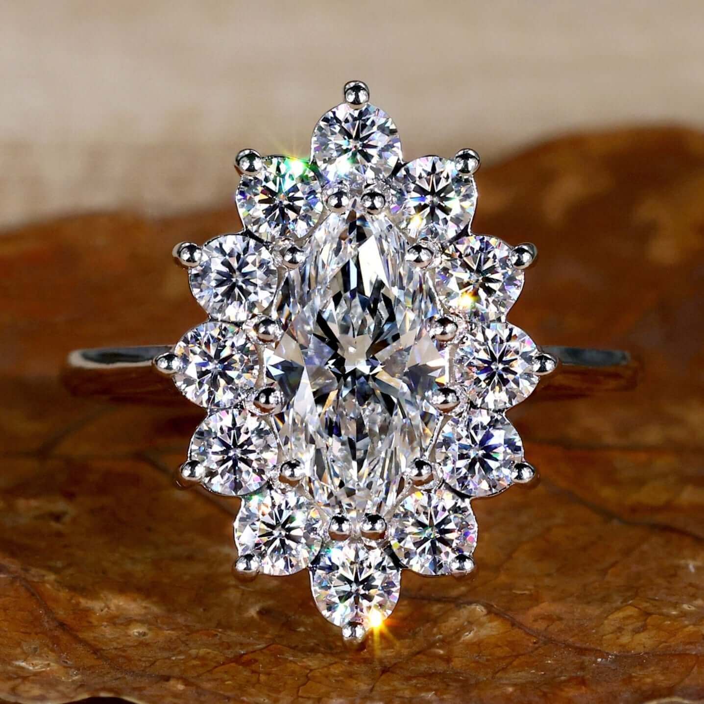 Cluster engagement ring with marquise cut diamond and prong setting for a timeless and elegant look.