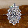 Cluster engagement ring with marquise cut diamond and prong setting for a timeless and elegant look.