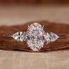 Three stone ring featuring an oval diamond with pear side stones, perfect for a unique engagement ring design.
