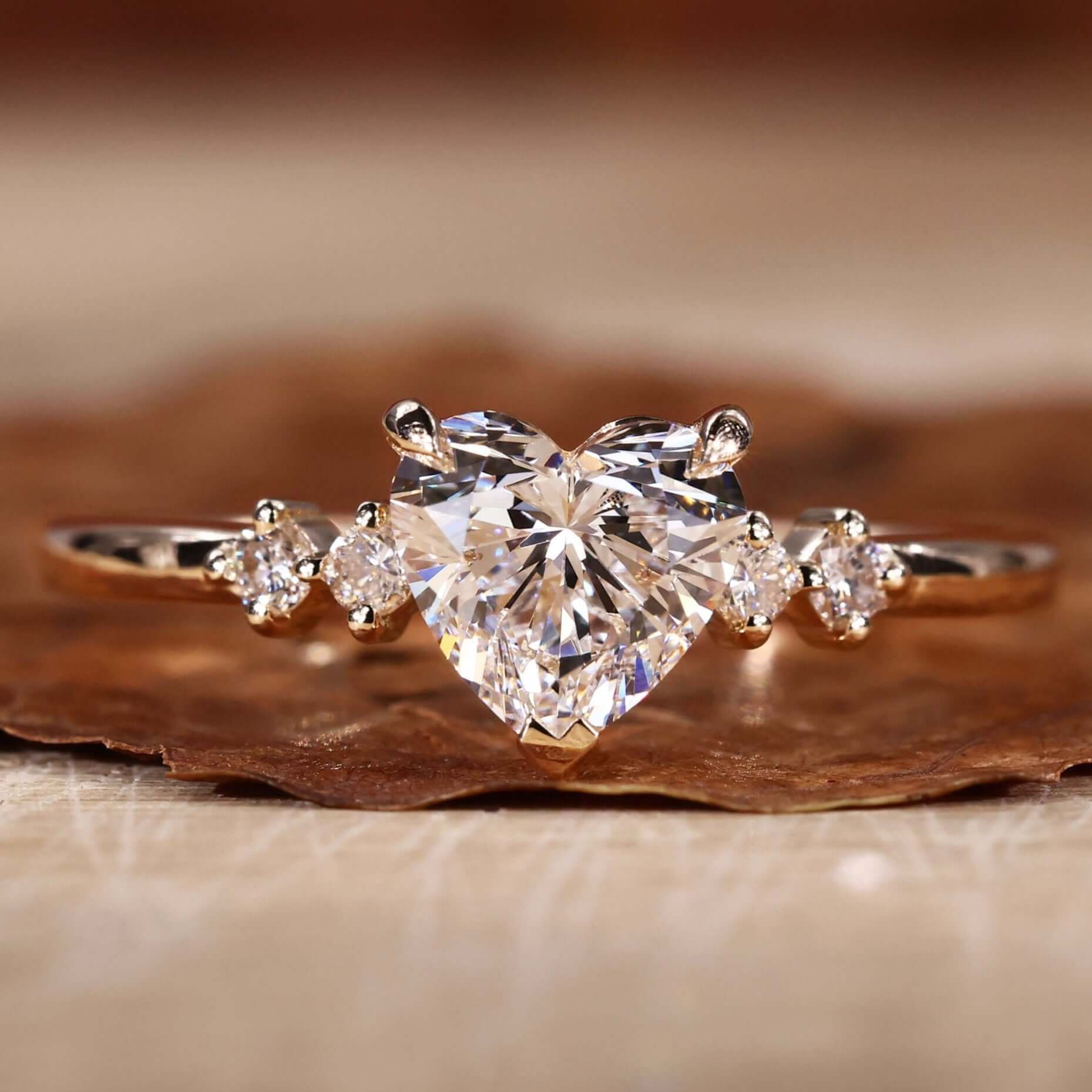 Heart shaped diamond ring with a stunning side stone design in a claw prong setting.