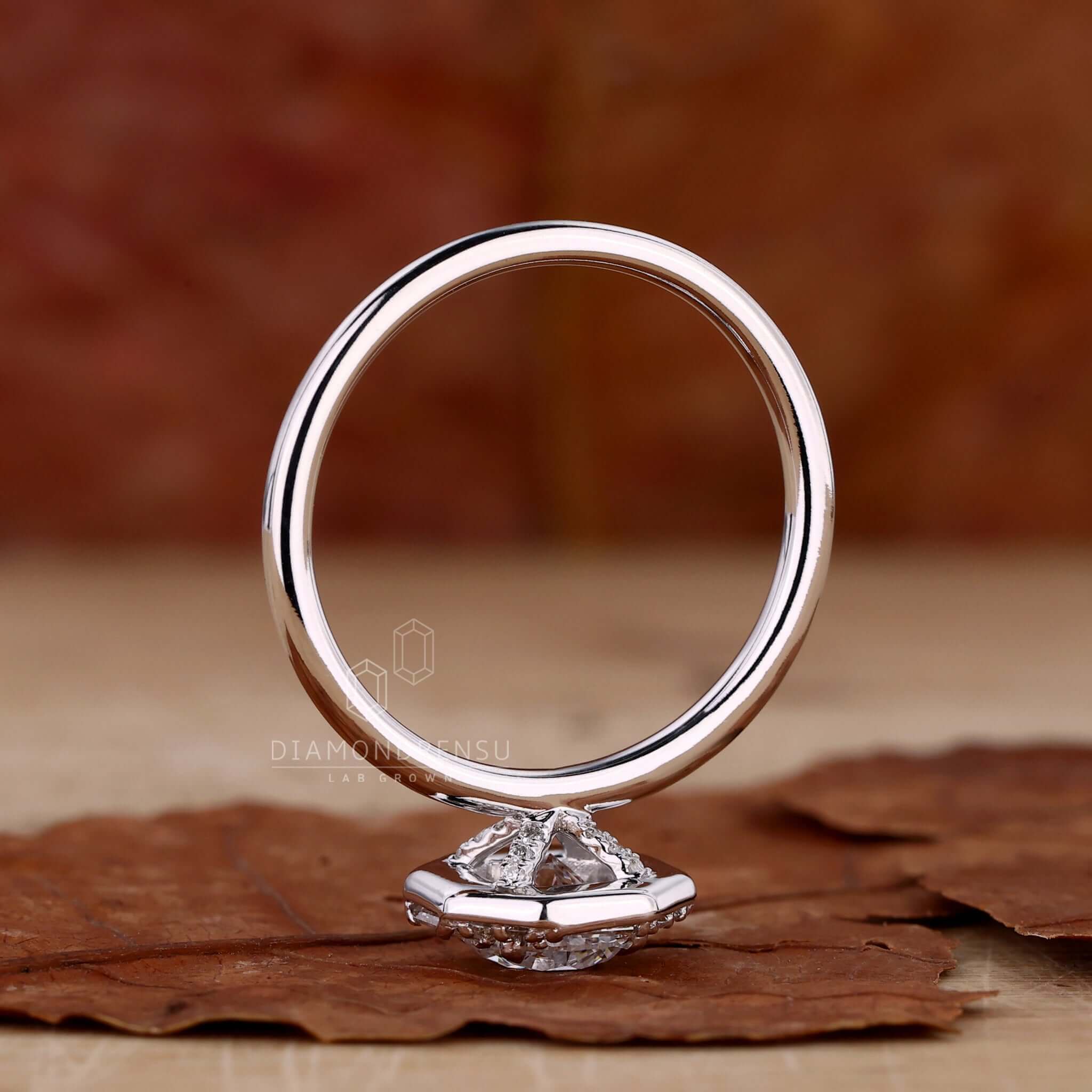 4 prong claw setting engagement ring with a round brilliant cut diamond and pave accents for a classic design.