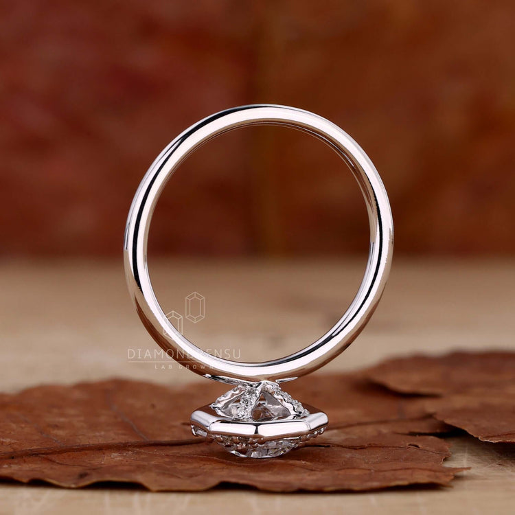 4 prong claw setting engagement ring with a round brilliant cut diamond and pave accents for a classic design.