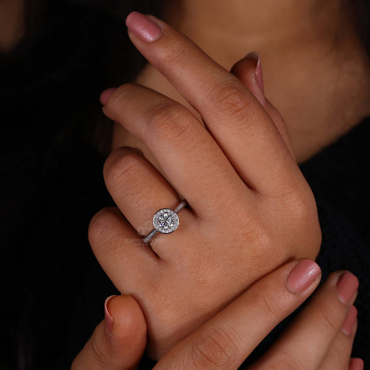 Round diamond ring featuring a halo design and pave diamond accents for added sparkle.