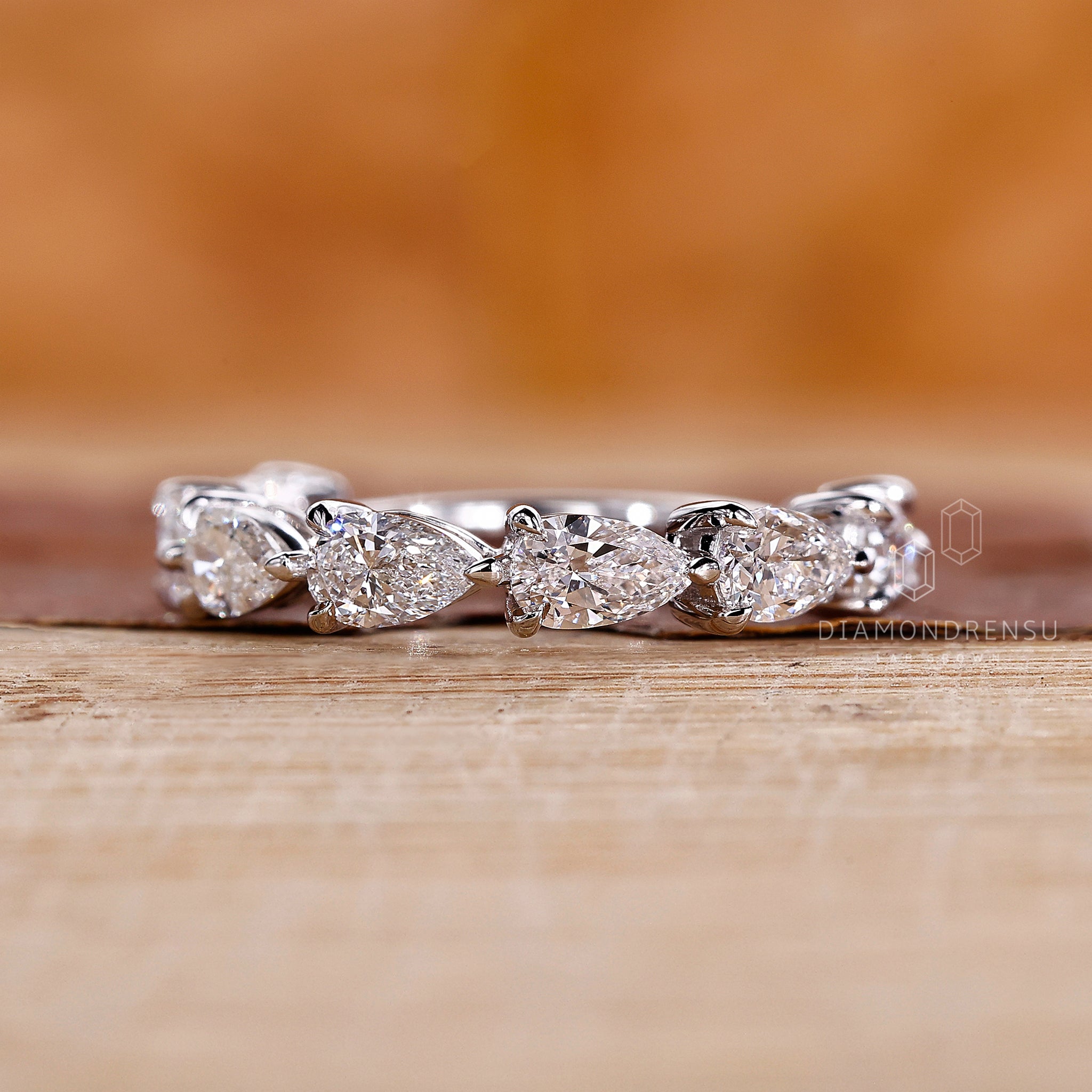 Claw prong pear diamond wedding band.