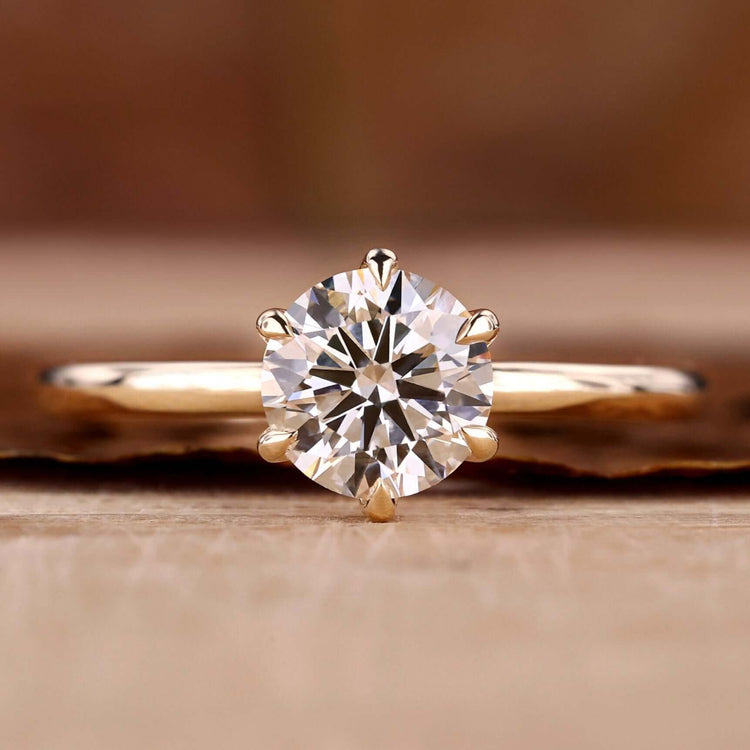 Gold solitaire engagement ring with a stunning handmade design.