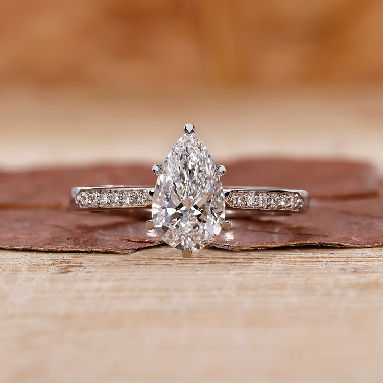 Pear shaped diamond ring with tapered pave engagement ring.