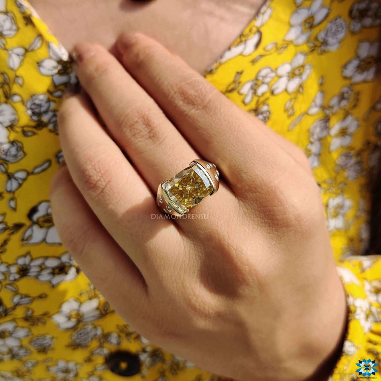 Yellow gold ring featuring tension set cushion moissanite center.