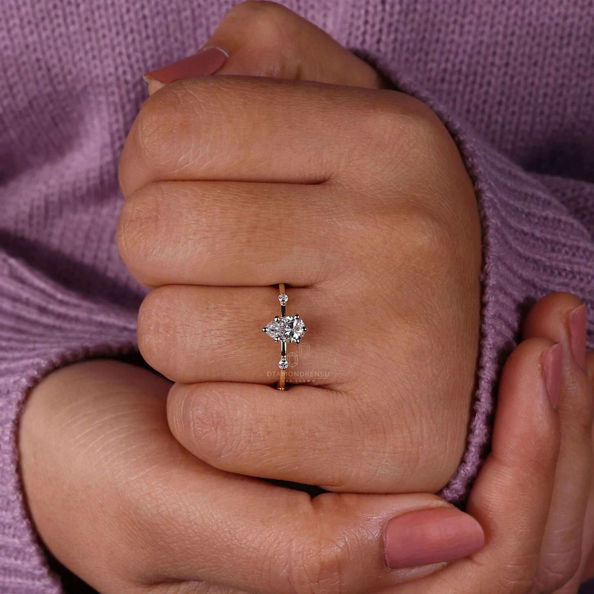 Pear diamond engagement ring paired with a yellow gold engagement ring for a classic and elegant look.