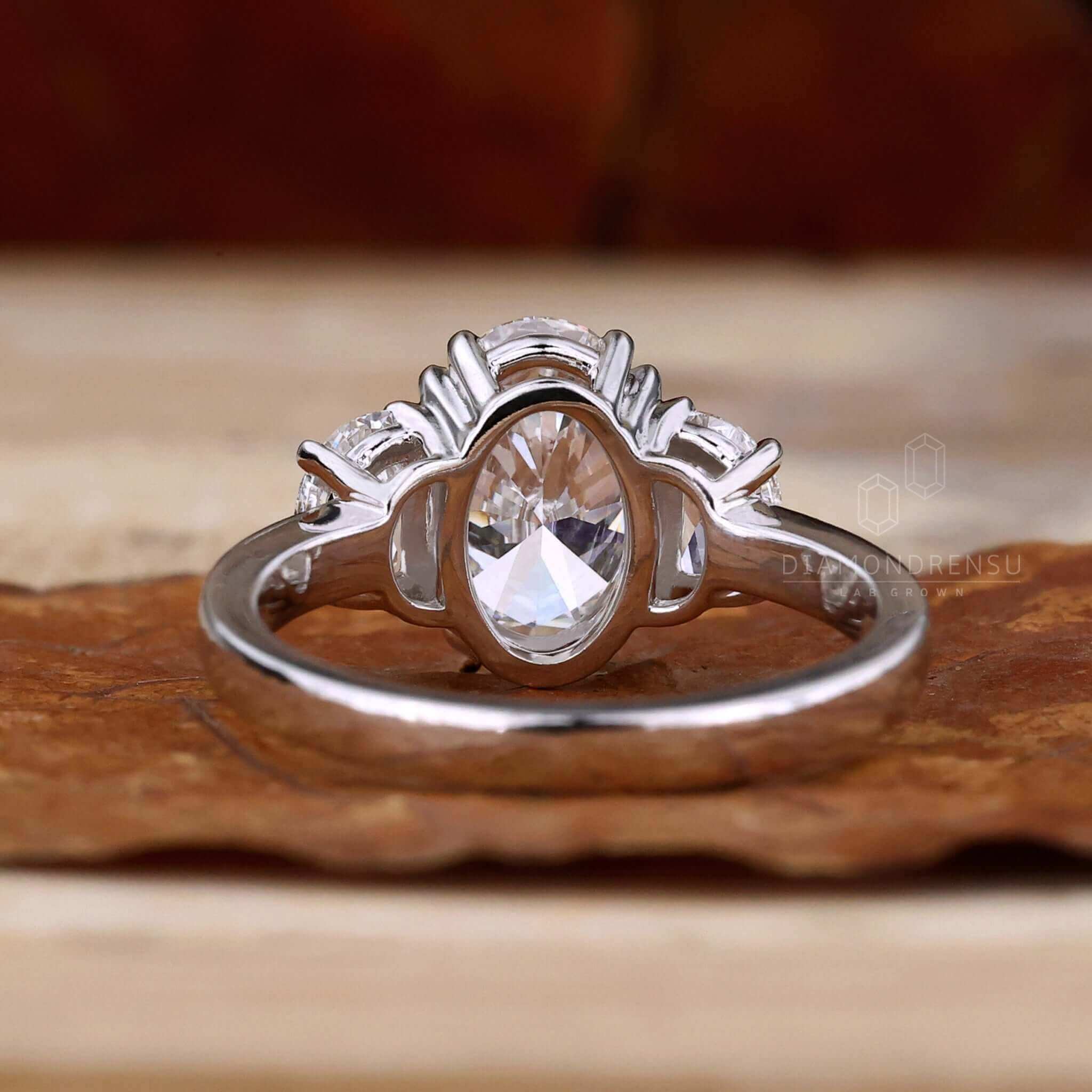 3 stone engagement ring design featuring an oval diamond and unique two half moon side stones for timeless elegance.