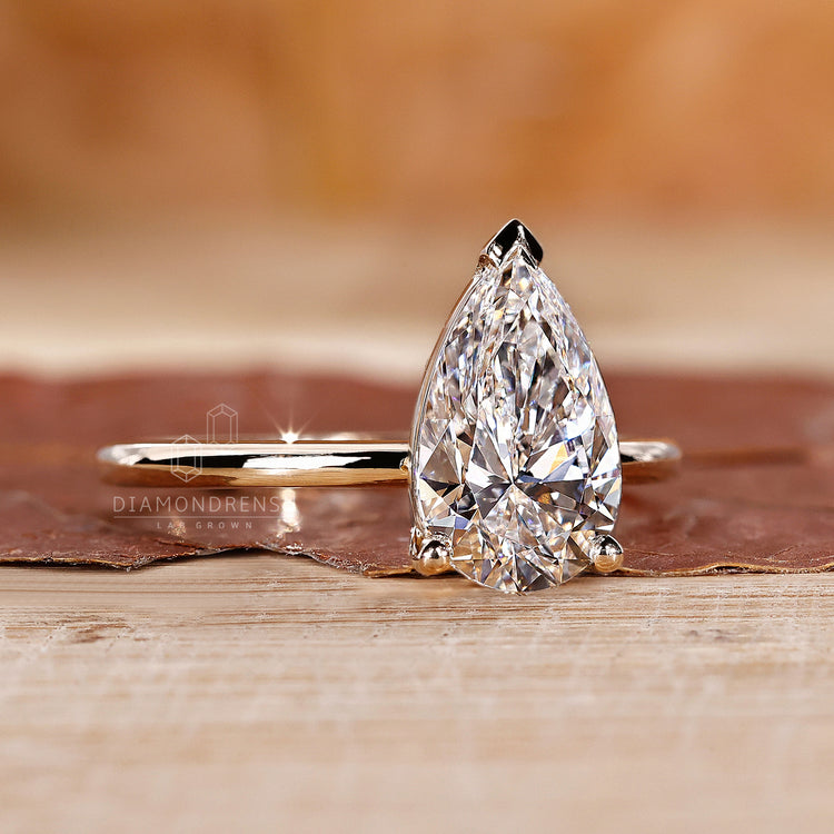 V prong ring featuring a lab grown pear cut diamond.
