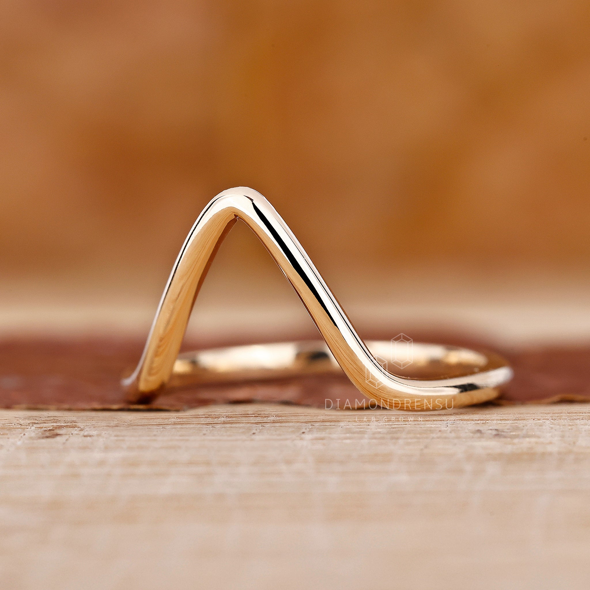 Simple wedding band in yellow gold with a soft V contour.