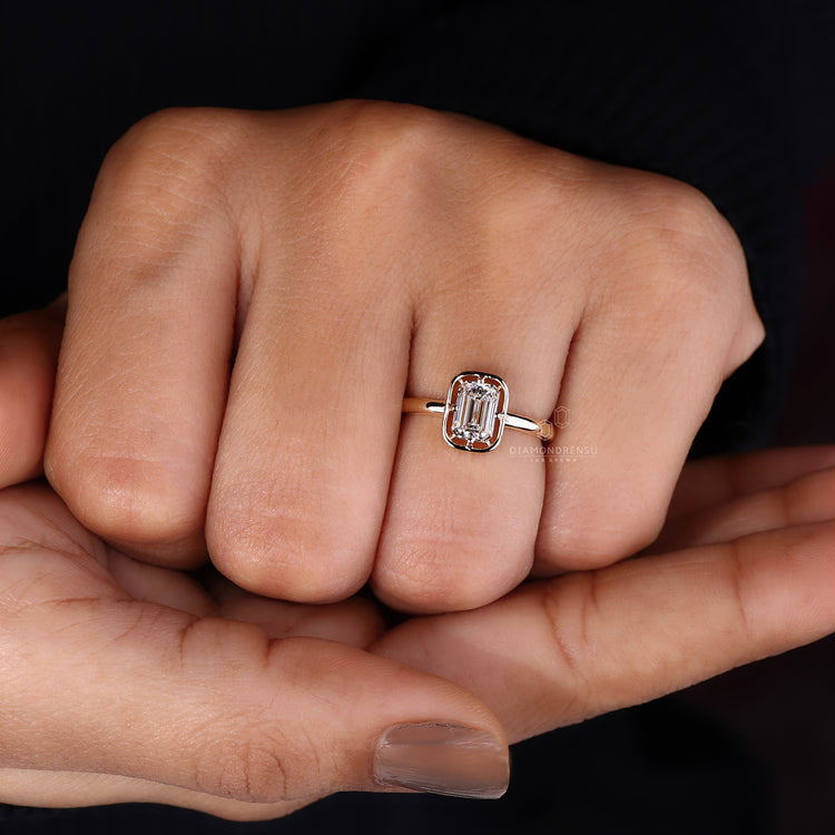 Unique engagement ring has emerald cut and solitaire setting.