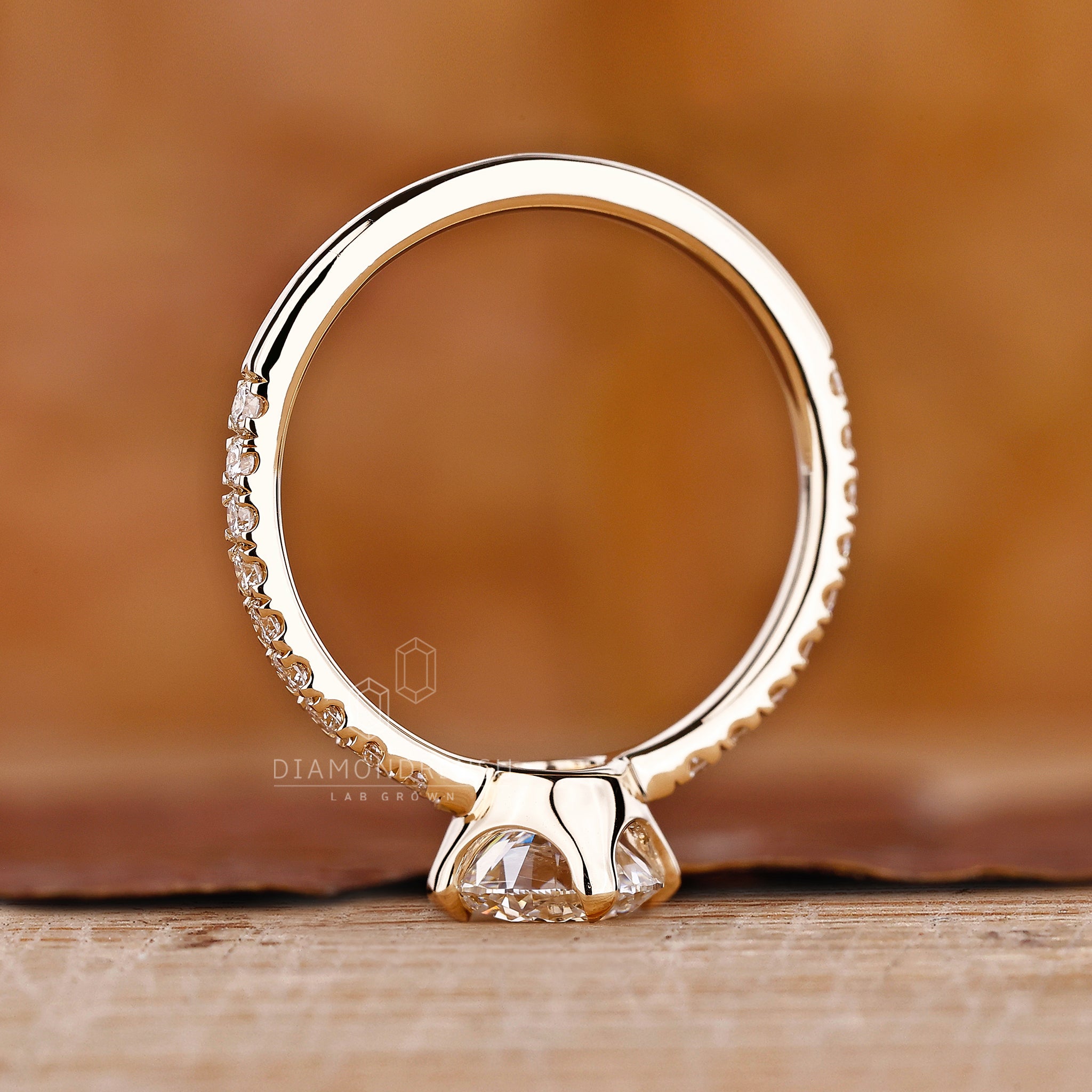 Custom engagement ring with four claw prong set and yellow gold style.