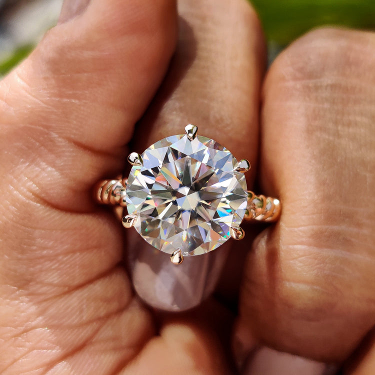 Round cut moissanite engagement ring with six claw prong in rose gold.