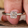 Gold engagement ring with a cushion cut diamond in a 4 prong claw setting for a timeless and elegant design.