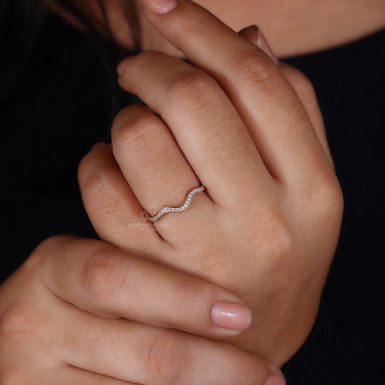 Curved yellow gold wedding band with round cut stones