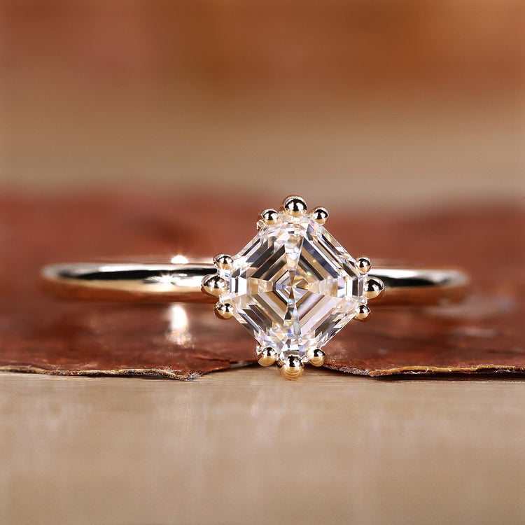 Asscher cut diamond ring in yellow gold setting.