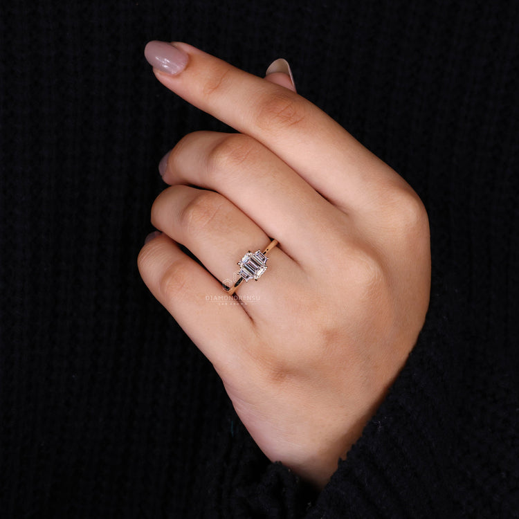 Three stone ring emerald cut with an IGI certified centre diamond.