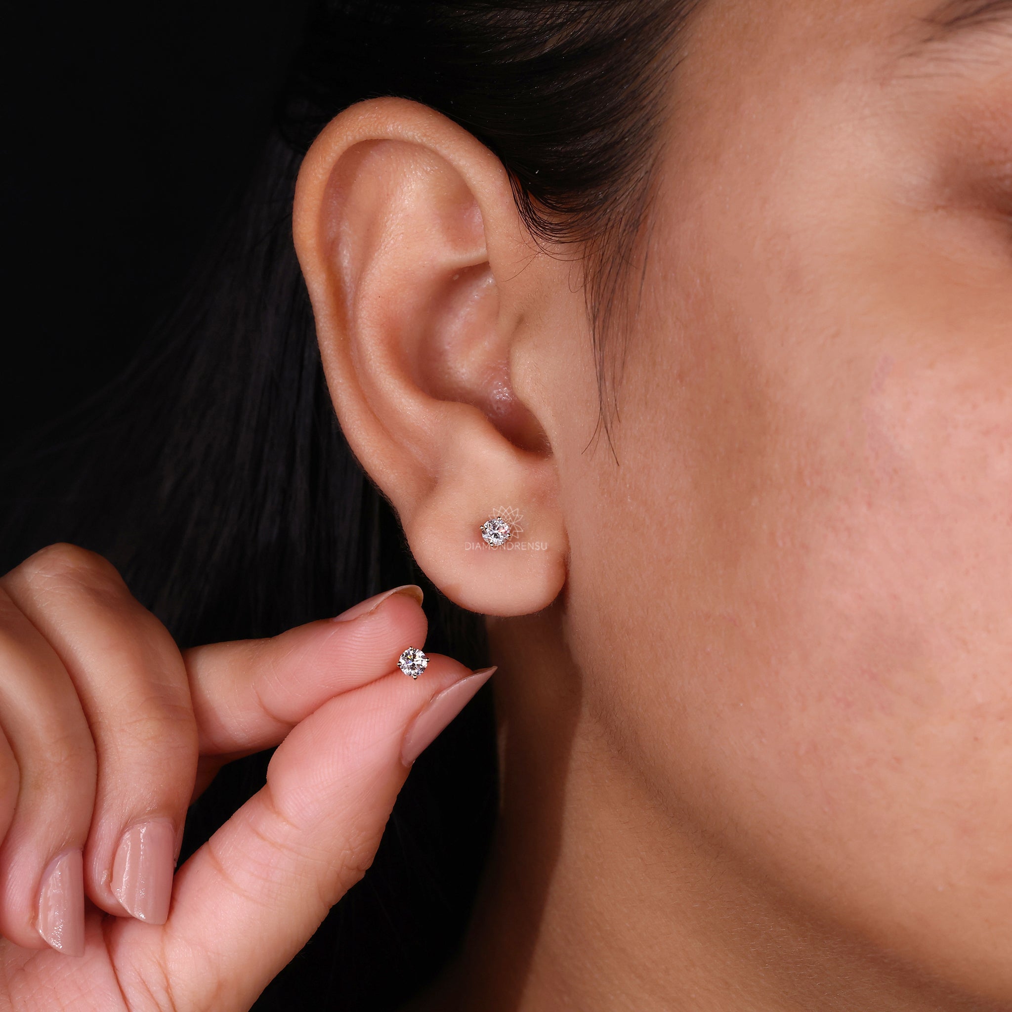 Dainty gold earrings with round cut diamonds.