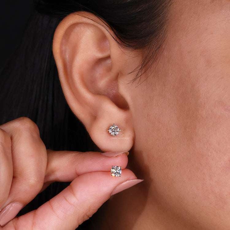 Custom diamond earrings crafted as simple round studs in yellow gold.