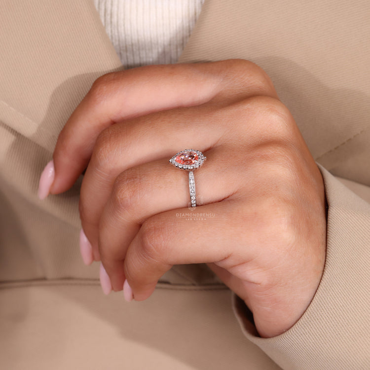 Buy engagement ring online with peach sapphire and halo details.