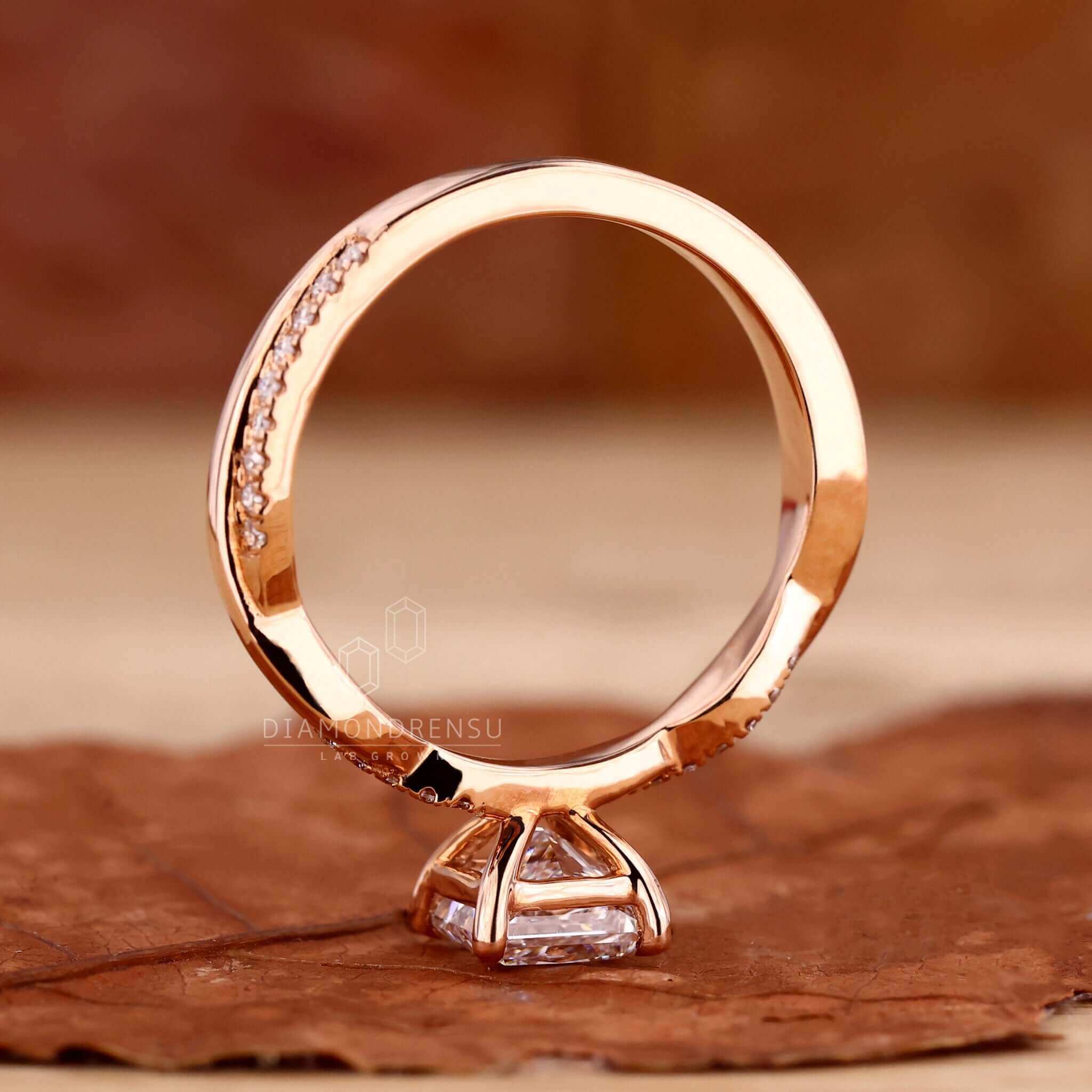 Claw prong engagement ring in rose gold with a unique princess cut diamond centre stone.