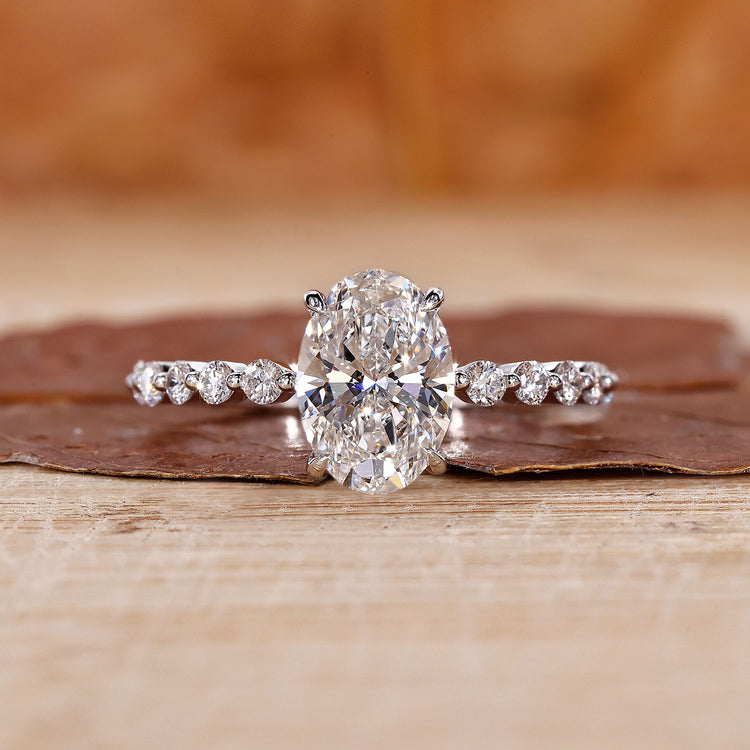 Oval diamond engagement ring with round cut pave setting.