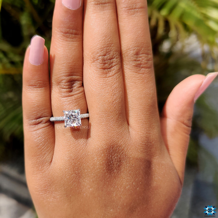 Moissanite engagement ring with white gold band and hidden halo setting.