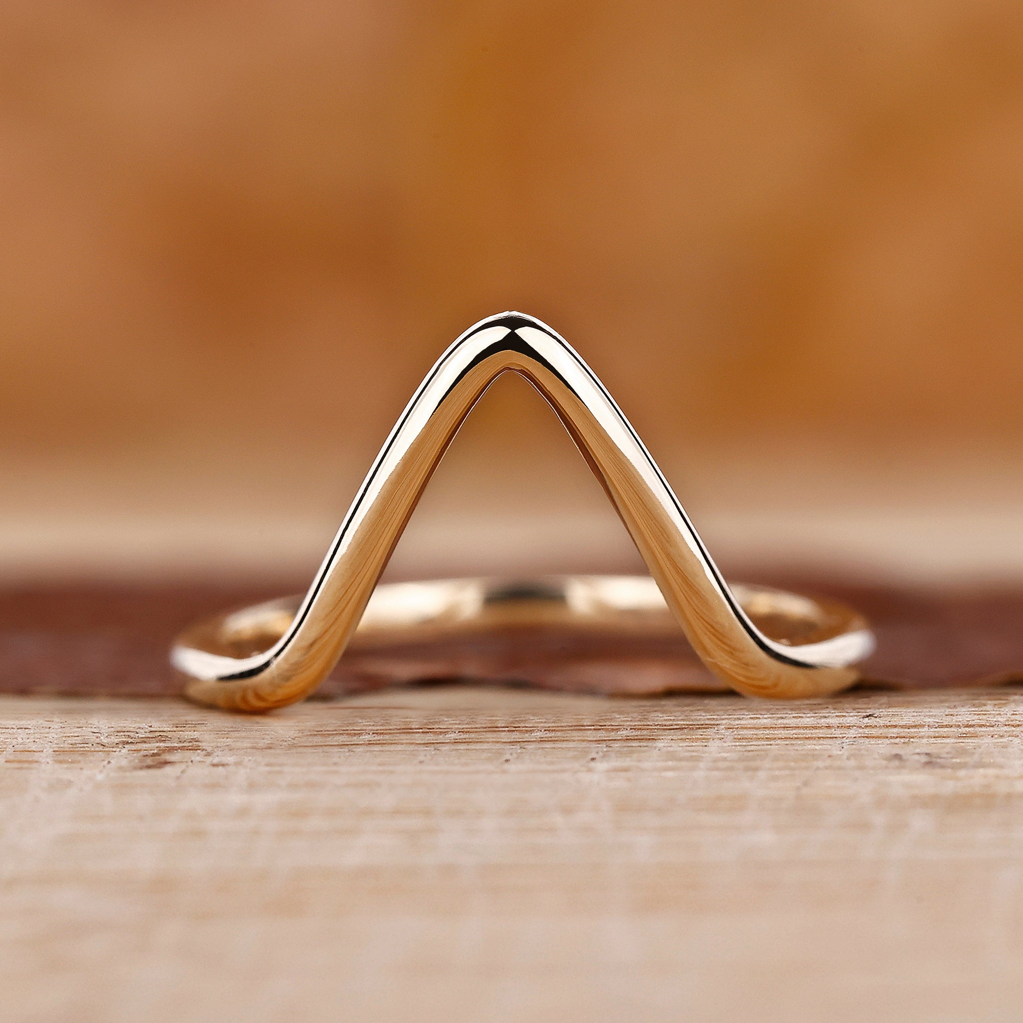 Chevron wedding band crafted in yellow gold with a modern curved shape.
