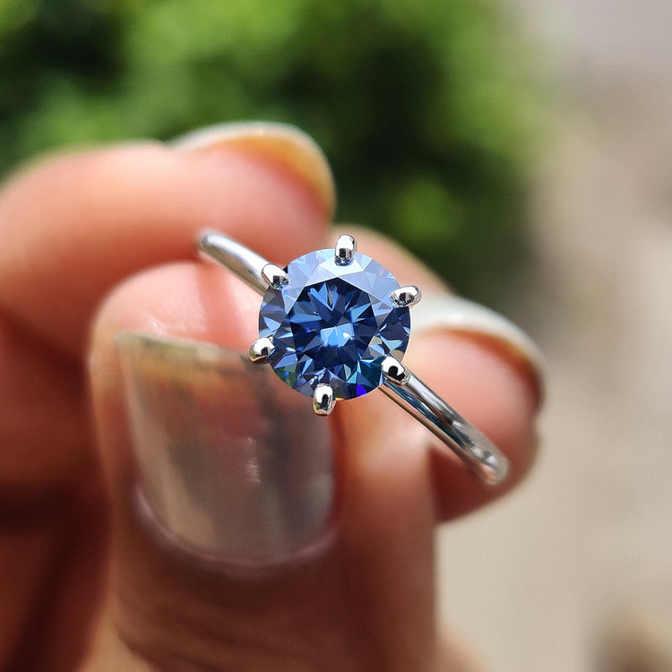 Blue moissanite ring in a round cut solitaire set in white gold.