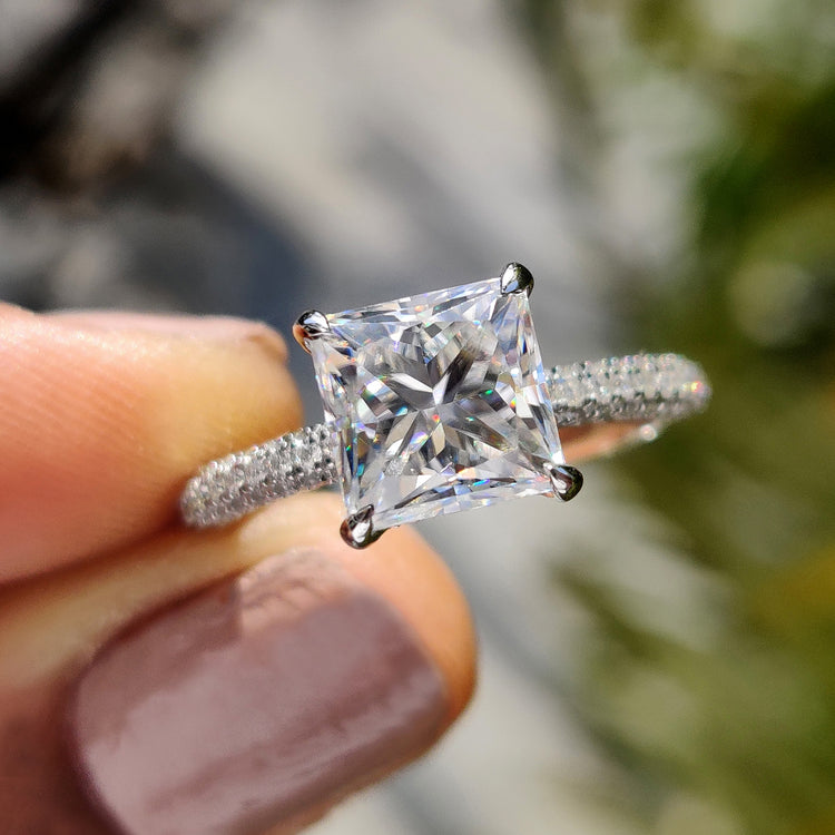 Princess cut moissanite ring with hidden halo and white gold band.