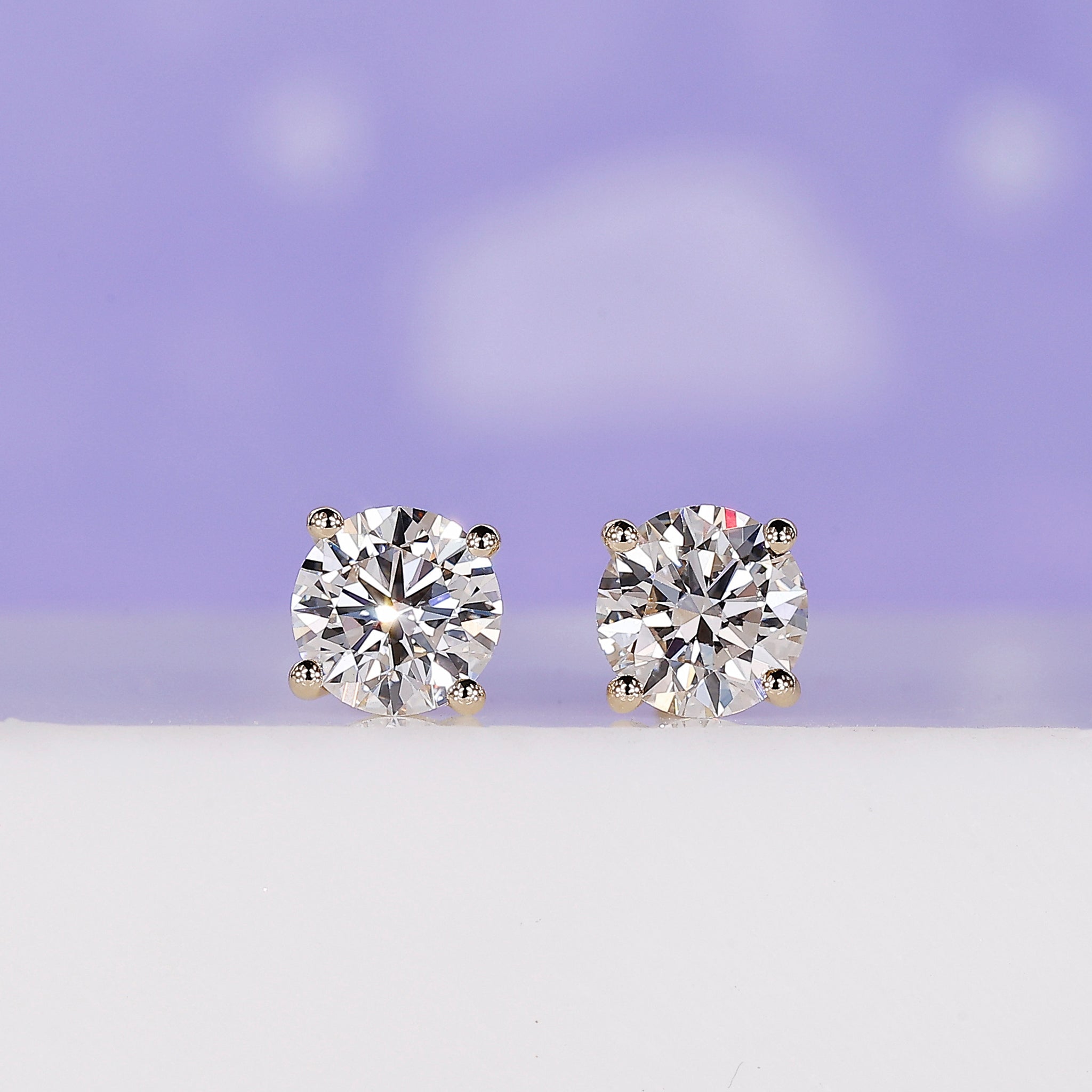 Yellow gold stud earrings featuring round cut lab grown diamonds.