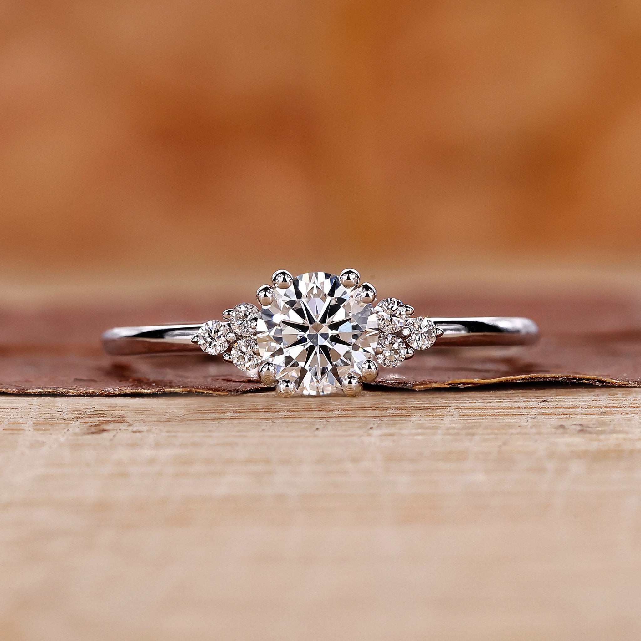 Round diamond engagement ring with round side diamond in muse setting.