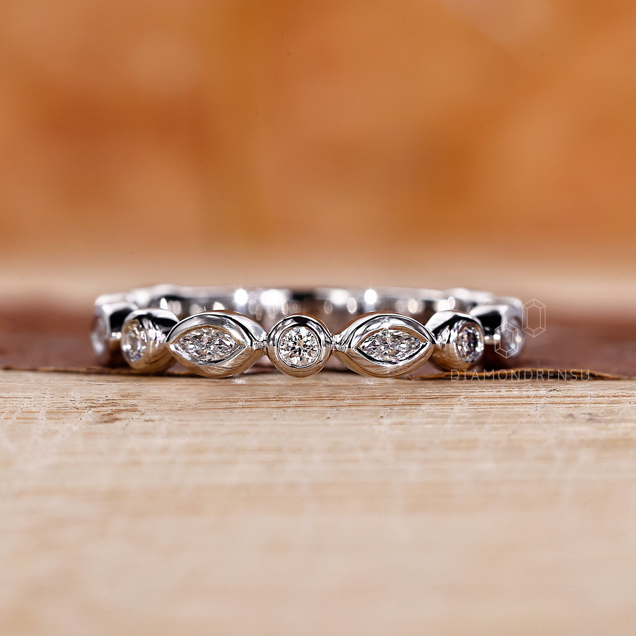 Minimalist wedding band featuring bezel set lab grown diamonds.