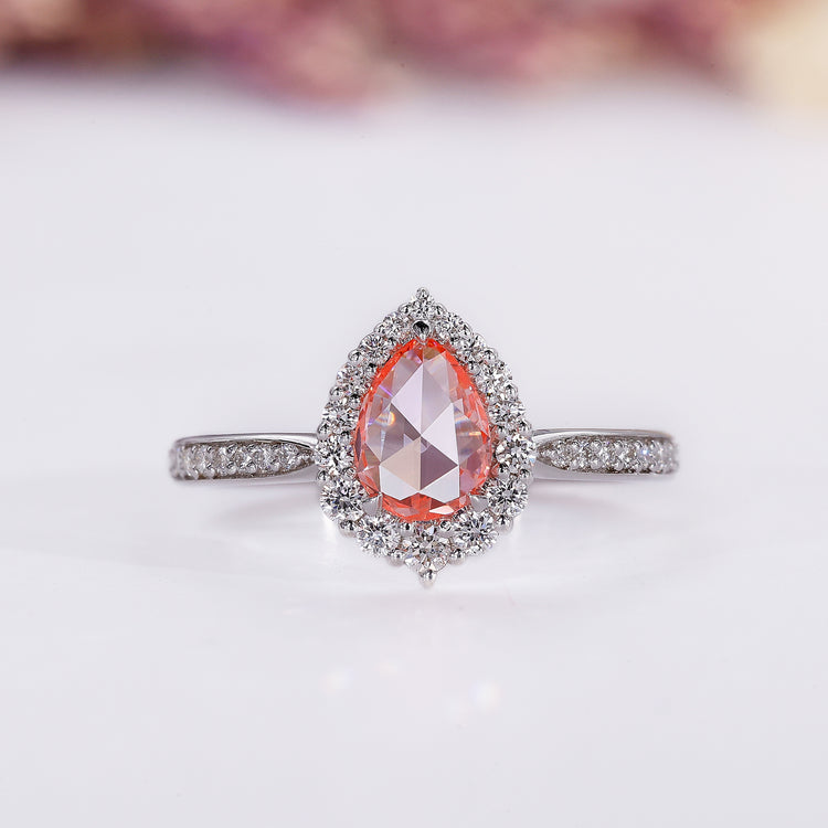 Peach sapphire ring with pear rose cut and halo diamond design.