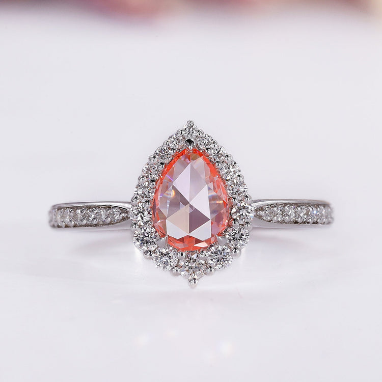 Peach sapphire ring with pear rose cut and halo diamond design.