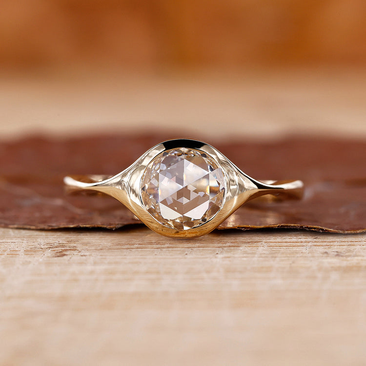 Bezel setting ring with round rose cut diamond in yellow gold.
