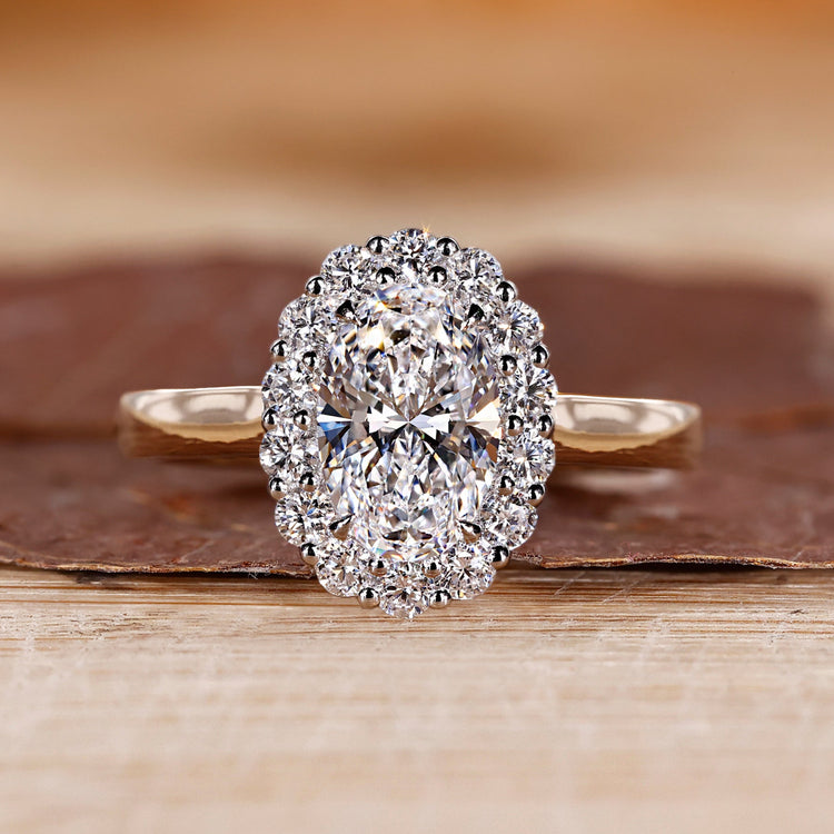 Oval diamond engagement ring with round cut halo.