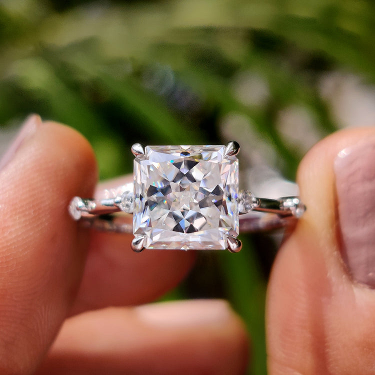 White gold moissanite ring with radiant Rensu cut and distance pave.