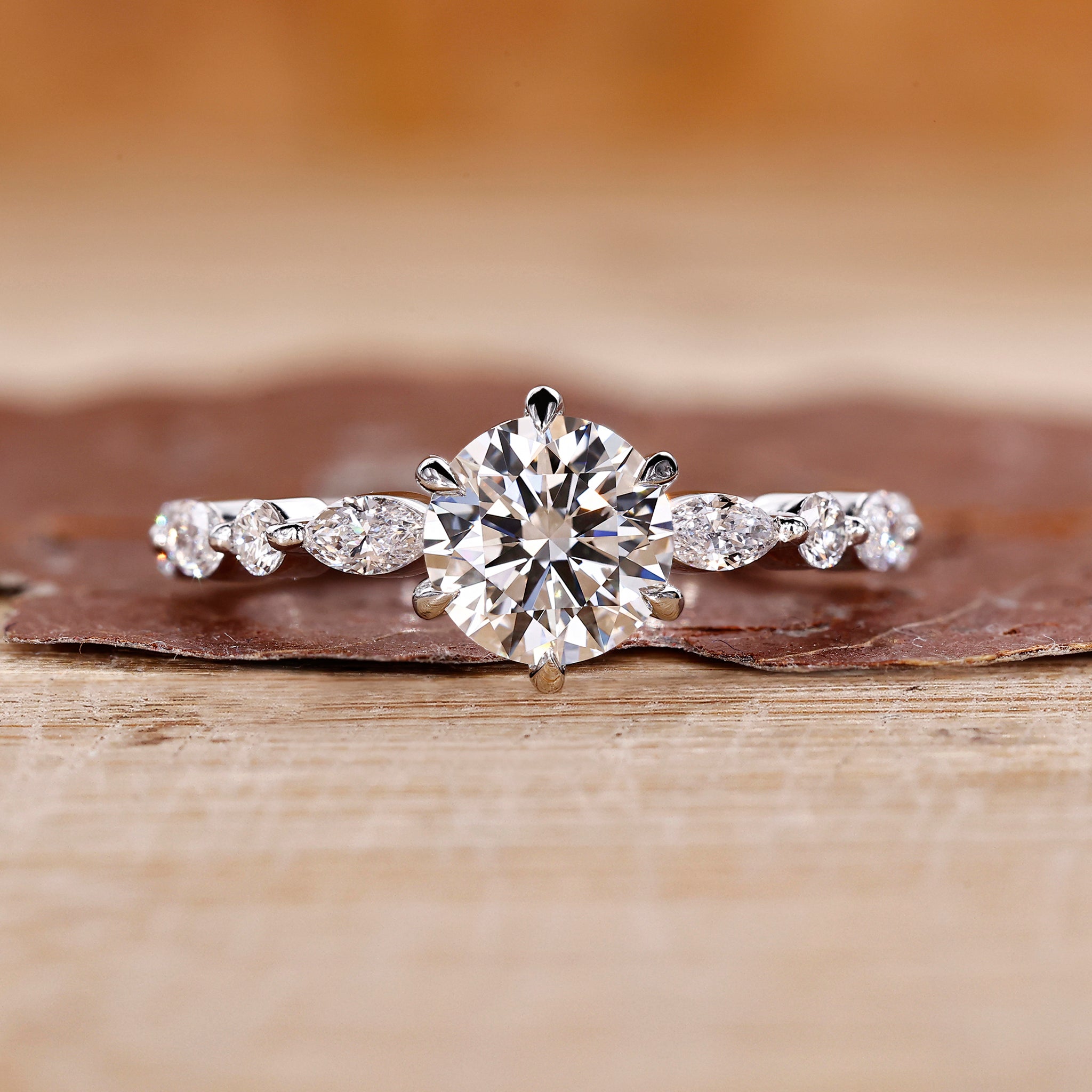 Round cut engagement ring with round and marquise side stones.