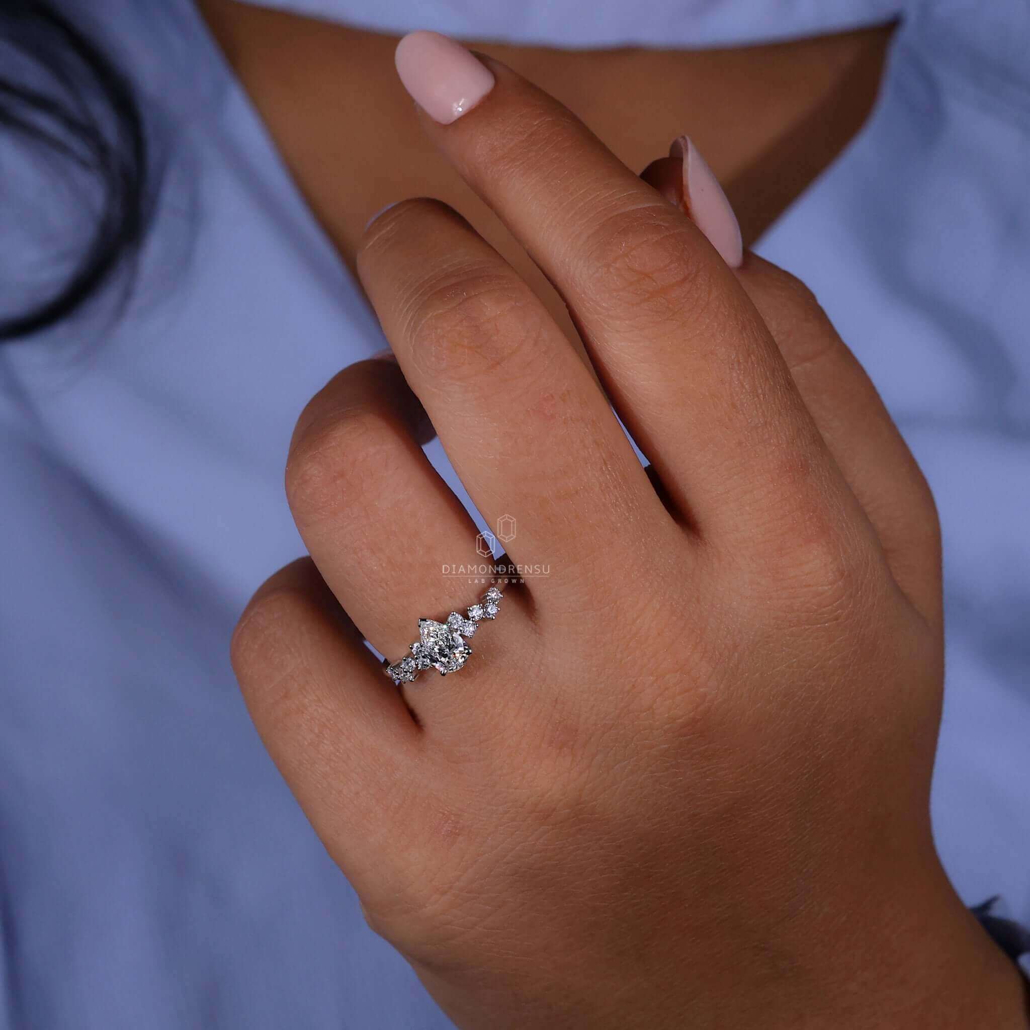 4 prong engagement ring featuring a pear shaped diamond with round side stones, perfect for women who love sophistication.