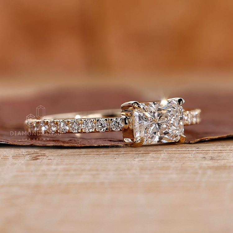 Proposal engagement ring with radiant diamond and yellow gold band.