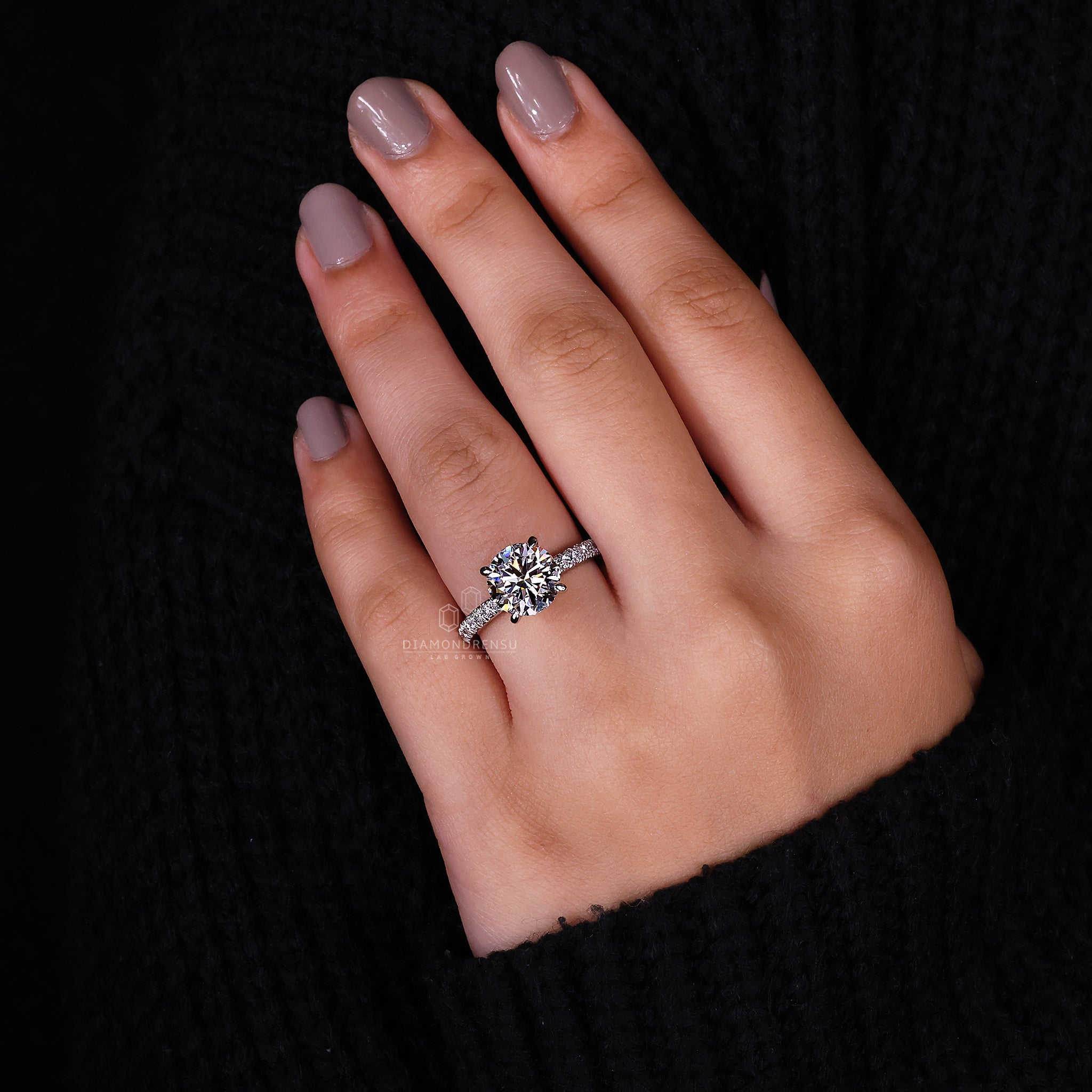 Engagement ring with a 4 claw prong setting and pavé accents.