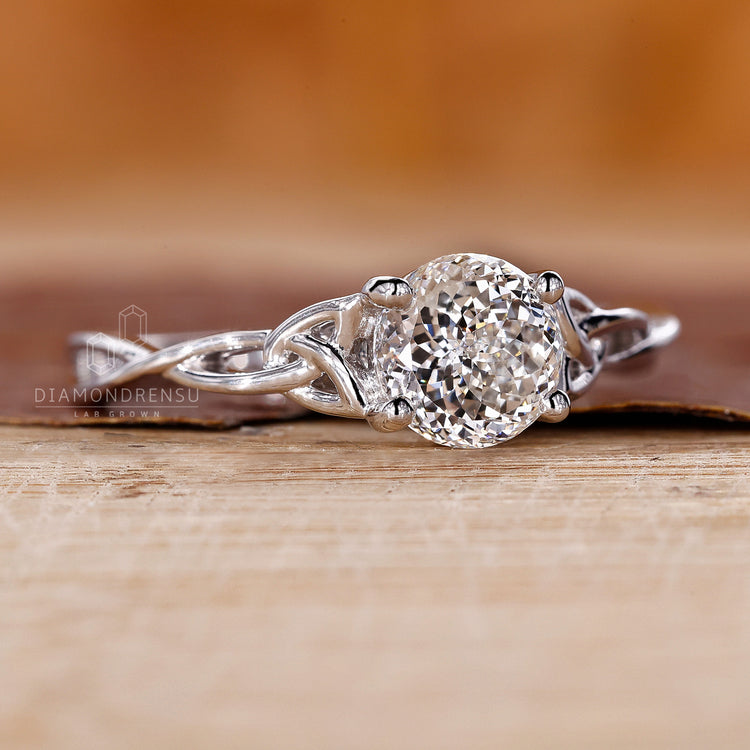 Solitaire diamond ring with twisted shank and prong setting.