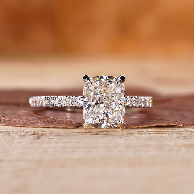Cushion diamond engagement ring with hidden halo and four claw prong ring.