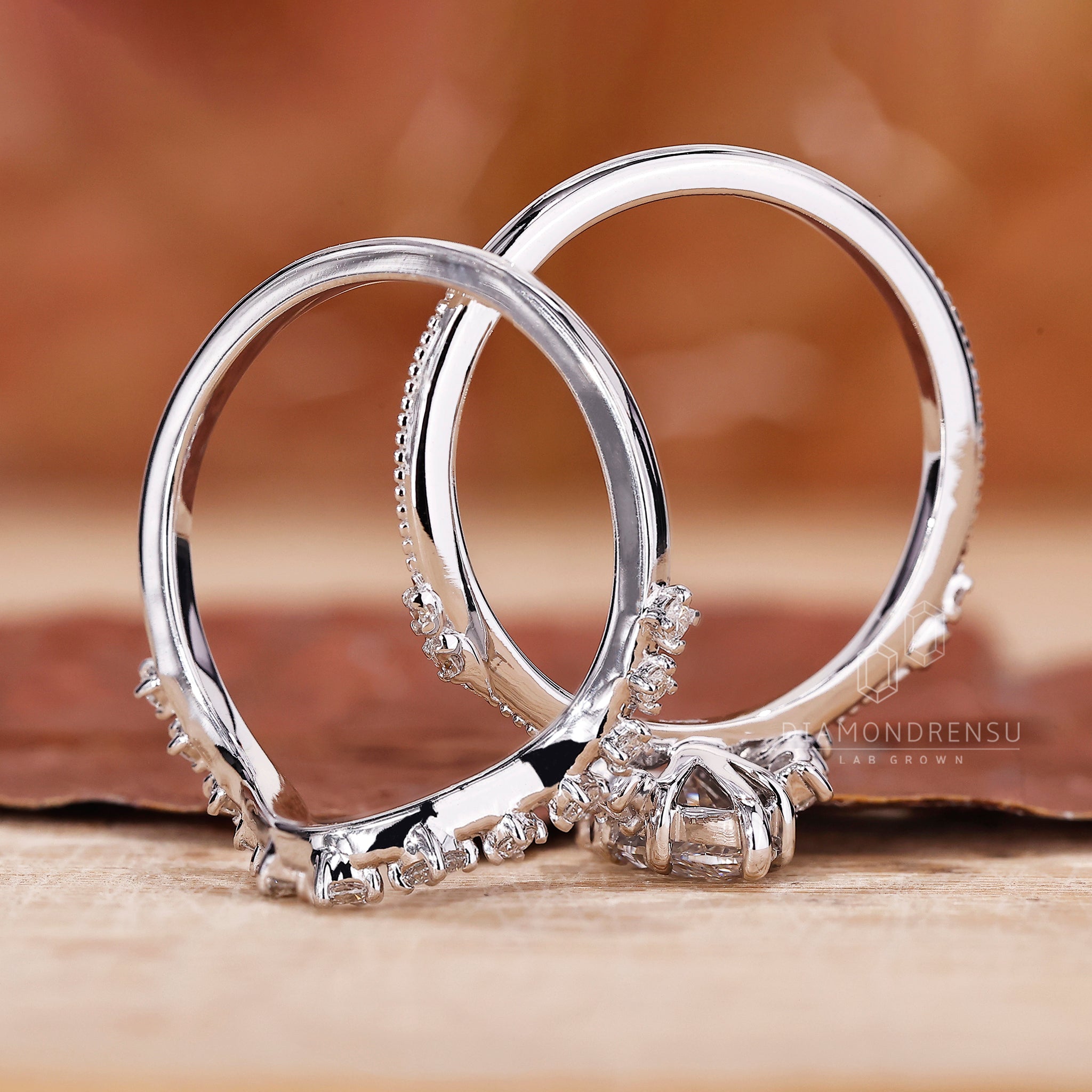 Round side stone paired with marquise engagement ring with wedding band.