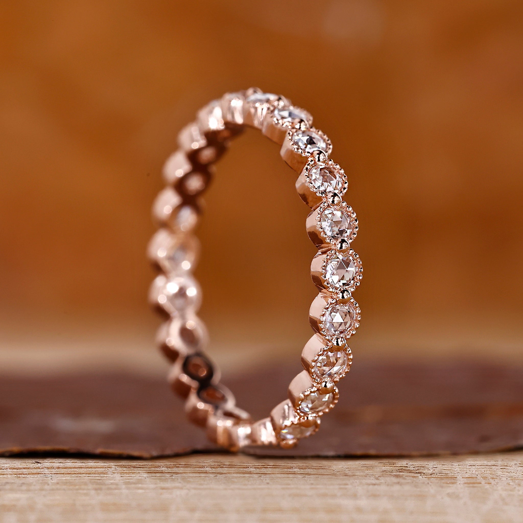 Round rose cut wedding band with a shared prong setting in rose gold.