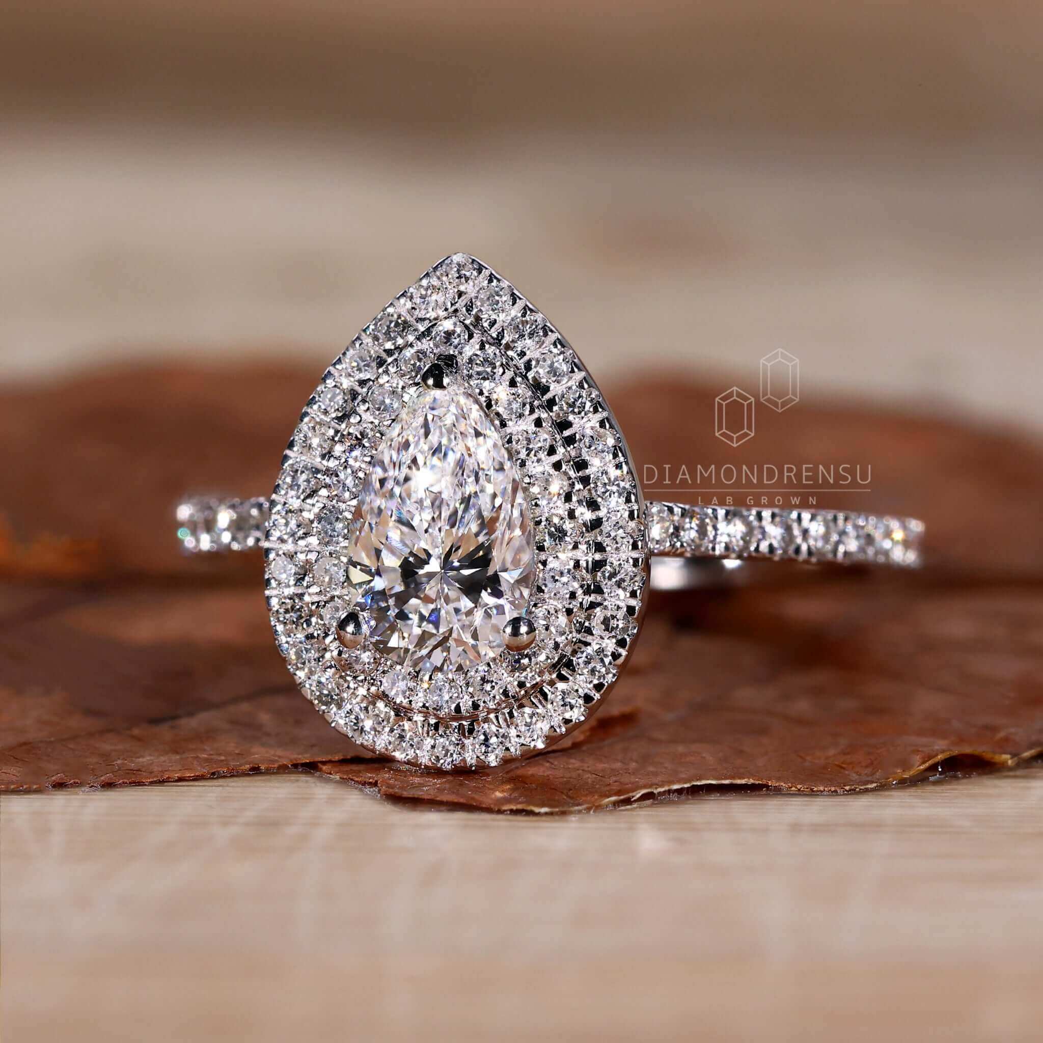 Pear shape diamond ring with pave diamond ring details and an exquisite white gold finish.